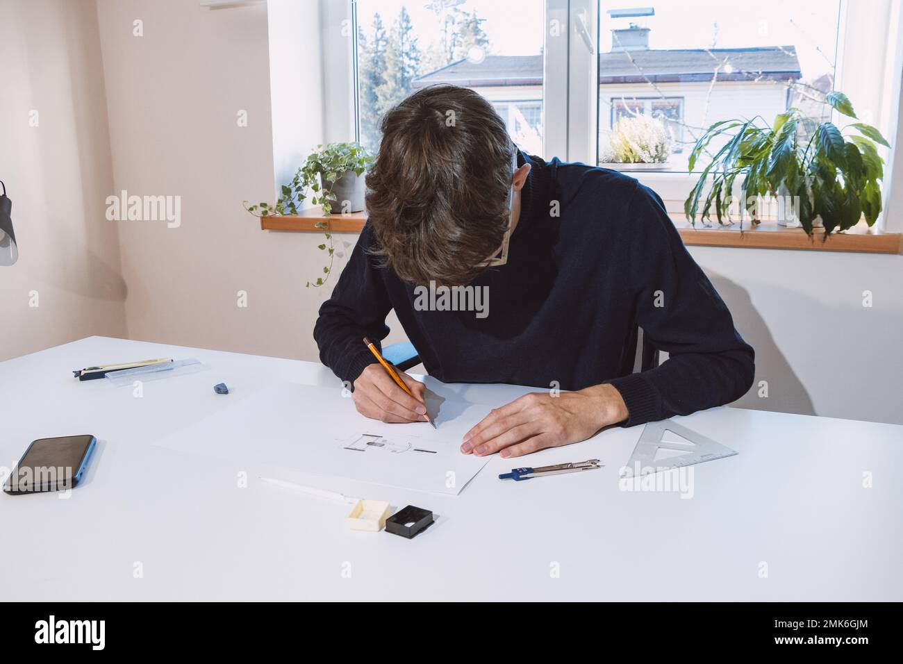 Brown-haired young architect creates new product designs for a new ...