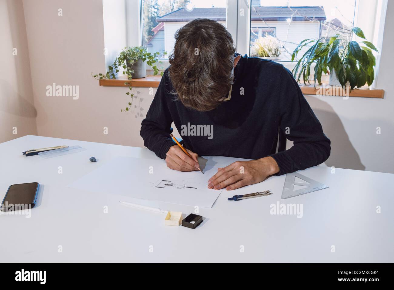 Brown-haired young architect creates new product designs for a new ...