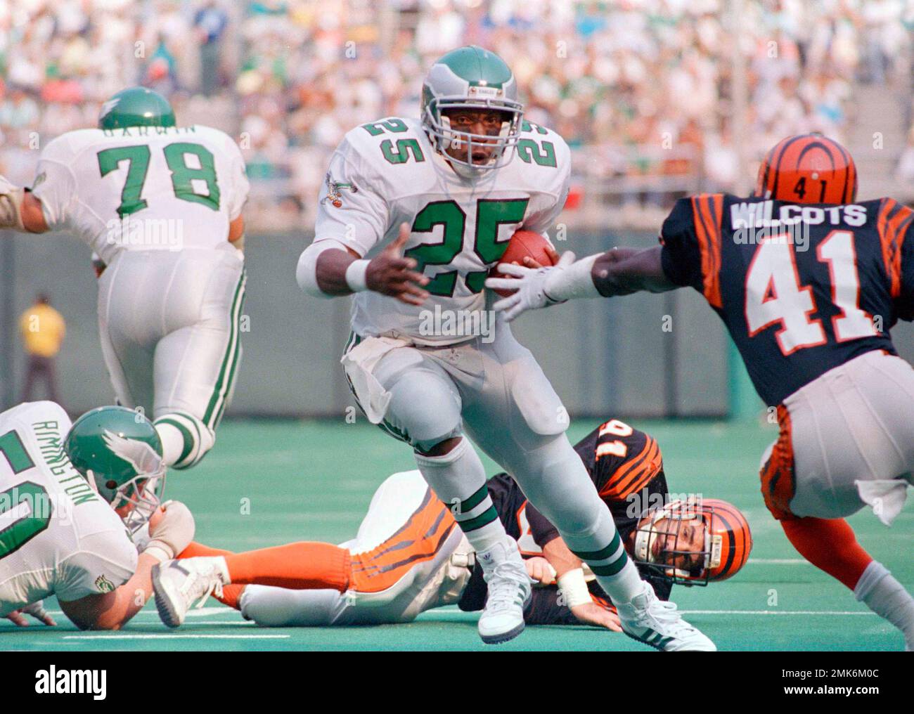 Eagles Anthony Toney, left, scampers nine yards against Cincinnati Bengals'  Solomon Wilcots, right, and a grounded Carl Zander, to score the first  touchdown in the first quarter in Philadelphia, Sept. 11, 1988. (