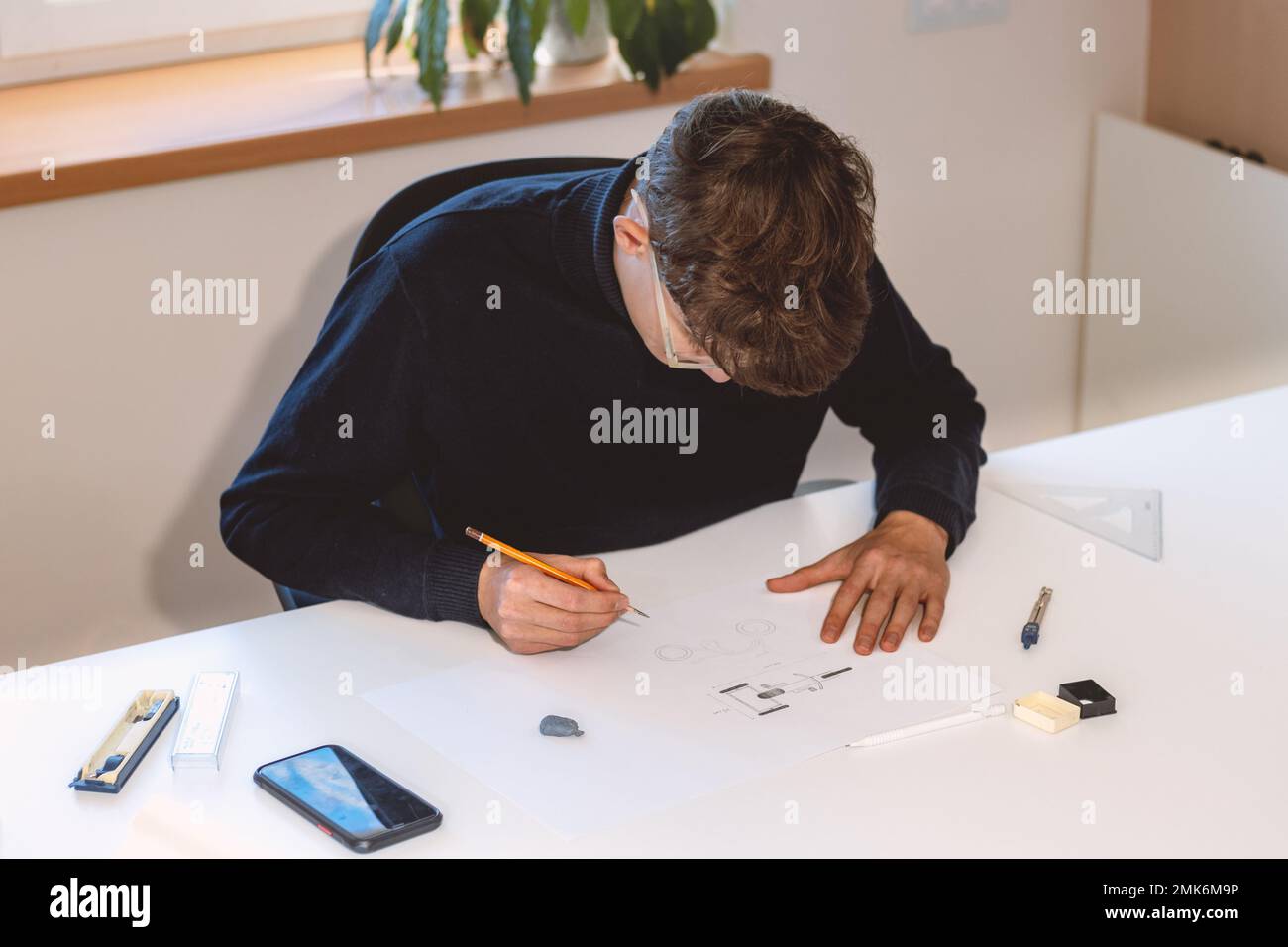 Brown-haired young architect creates new product designs for a new ...