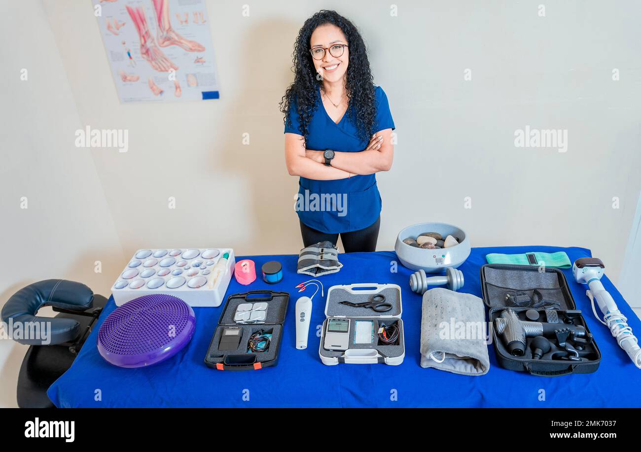 Physiotherapist woman showing therapy accessories and equipment. Physiotherapist with physiotherapy accessories. Smiling physiotherapist showing Stock Photo