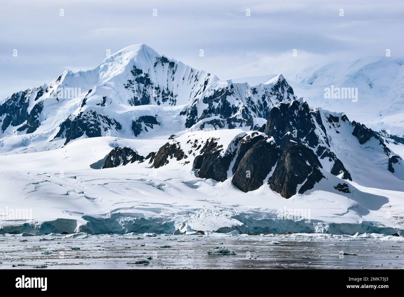 snow and ice covered mountains and glacier at Petermann Island ...