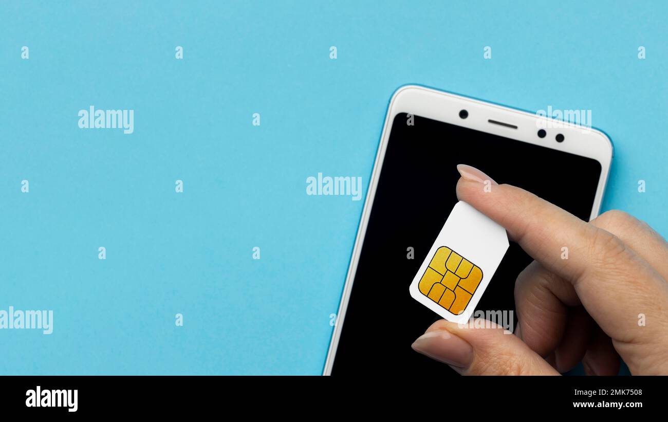 top view hand holding sim card with smartphone copy space. High resolution photo Stock Photo