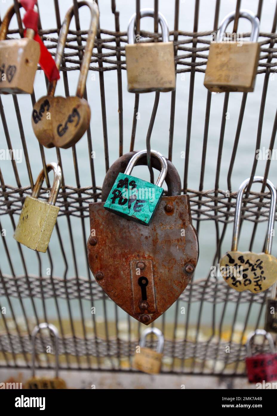Love locks attached to the railing of a bridge over the Seine River in Paris. Stock Photo