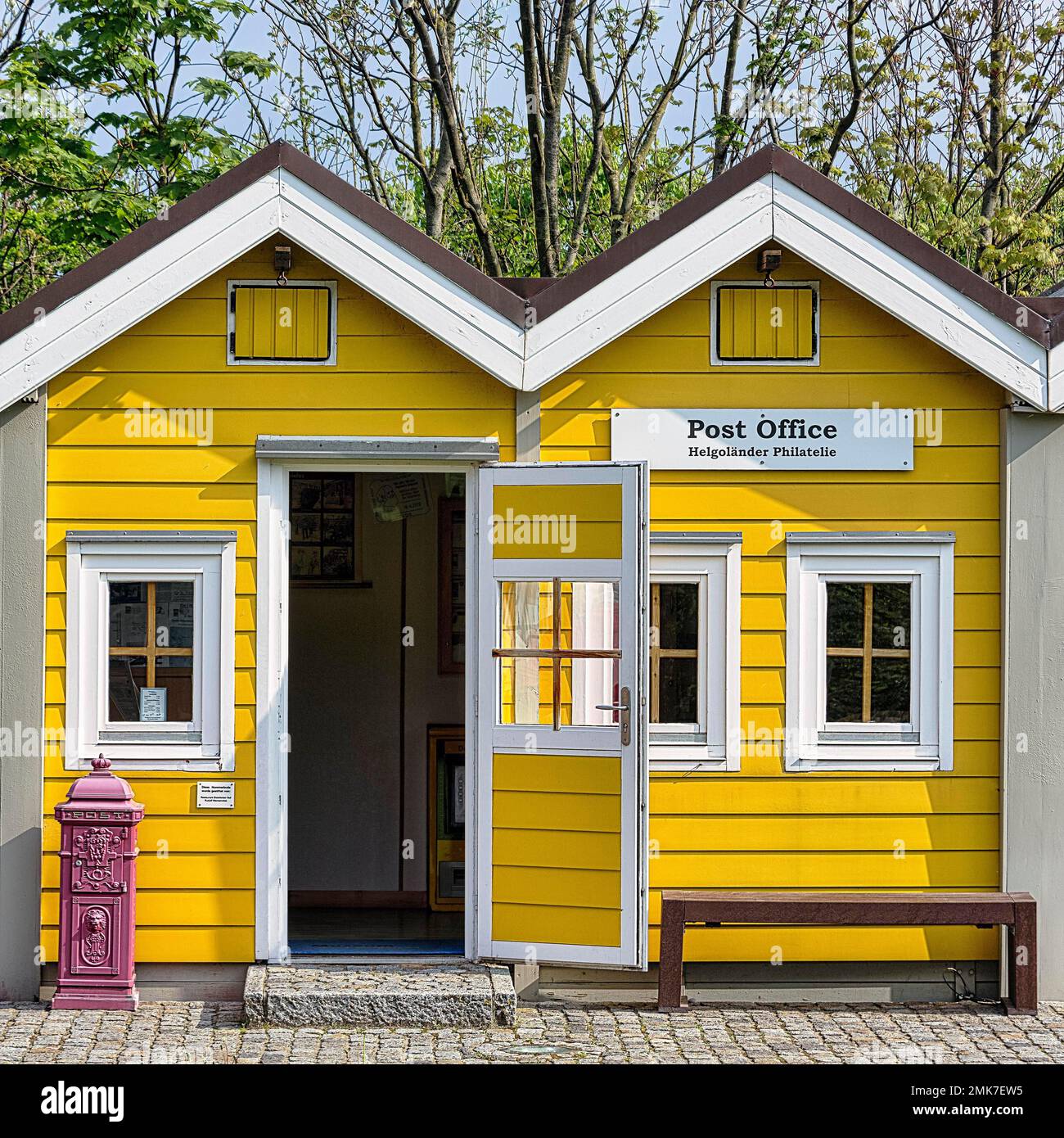 Yellow lobster shack with red letterbox, sign with inscription Post