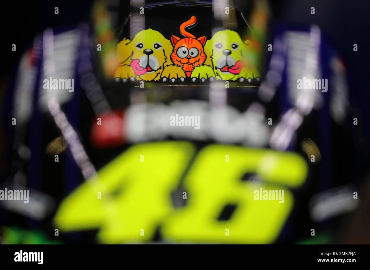 This photo shows a sticker that features two dogs and a cat is seen on the  motorcycle of Valentino Rossi of Italy during a Moto GP practice run in  Termas de Rio