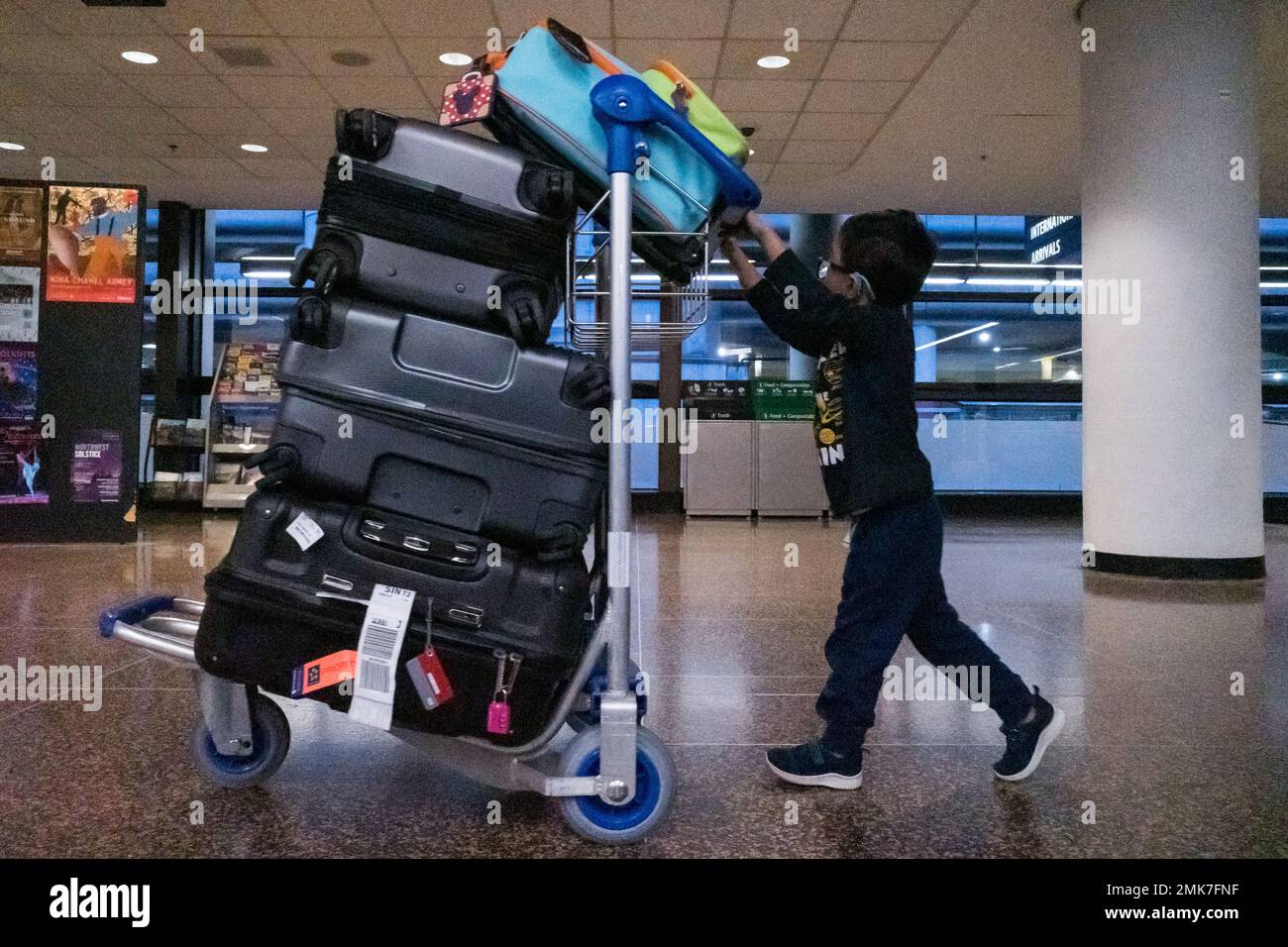 Seattle, USA. 12th Jan, 2023. A child pushing a full luggage cart at