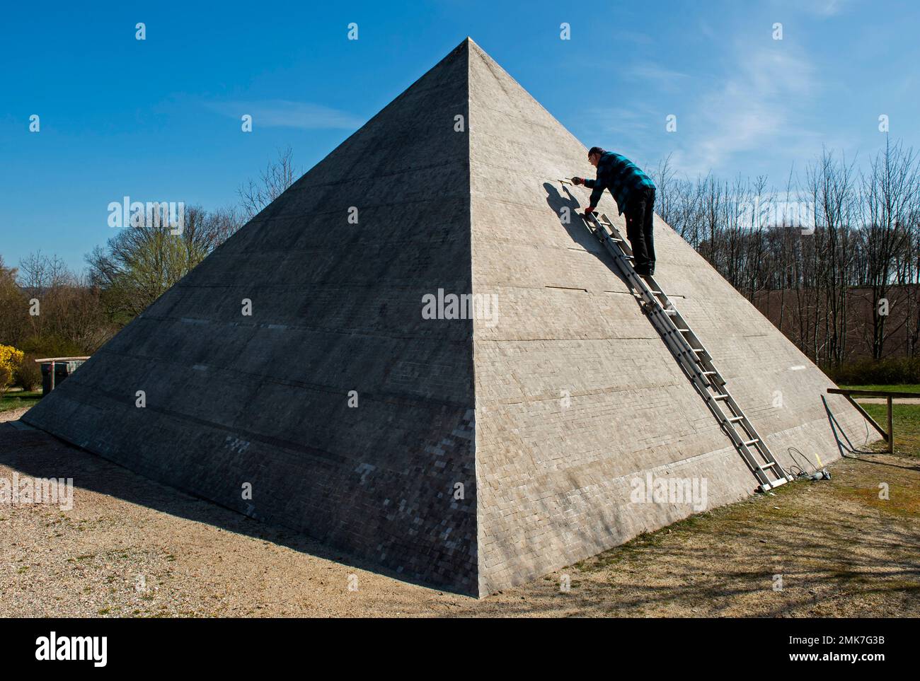 A worker fixes small stones at the model of the Cheops pyramid of Giza ...