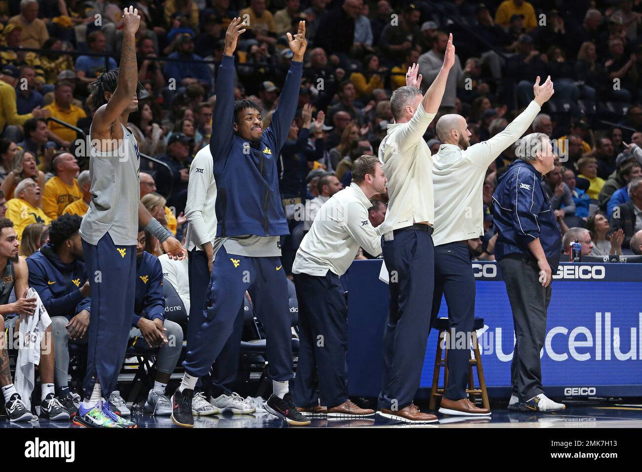 West Virginia players and coaching staff react from the bench during