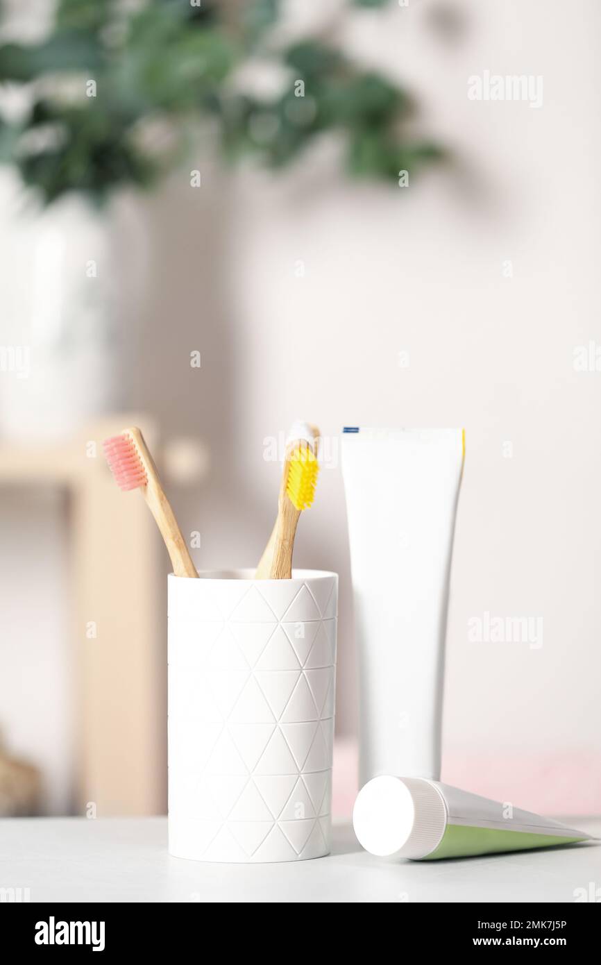 Bamboo toothbrushes and paste on light table indoors Stock Photo