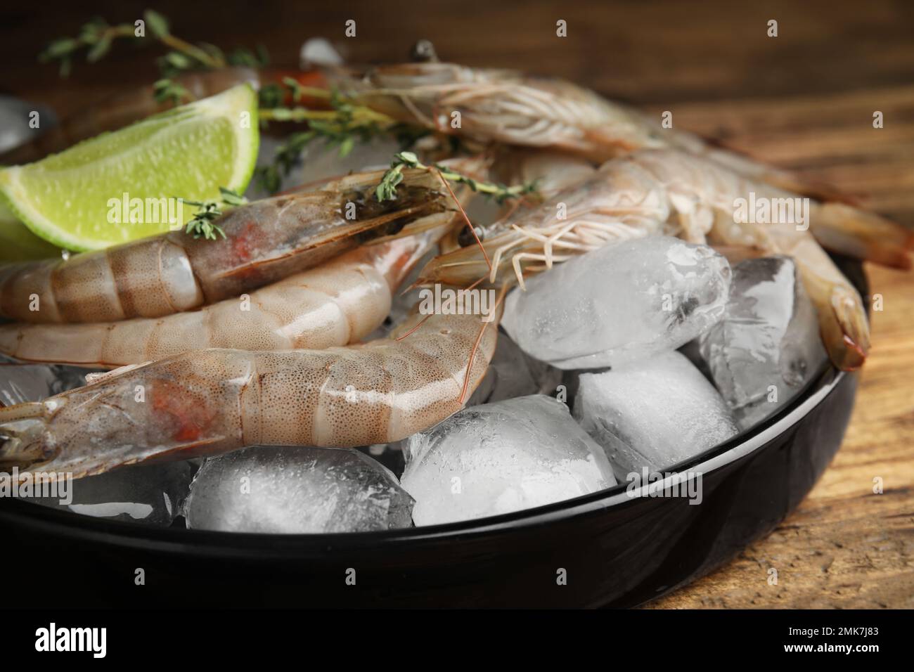 Fresh raw shrimps with ice on table, closeup Stock Photo