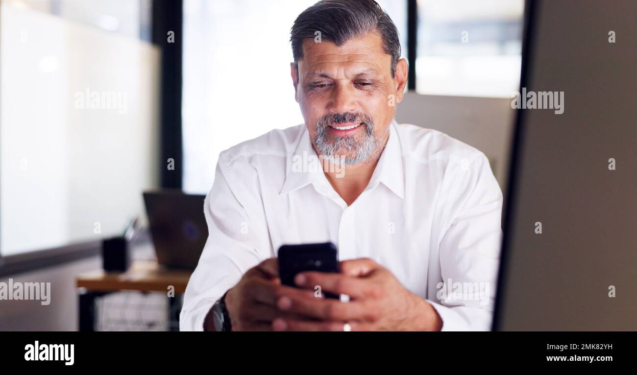 Business man, phone and office while typing for communication or chat about work while happy with network service, data and connection. Senior Stock Photo