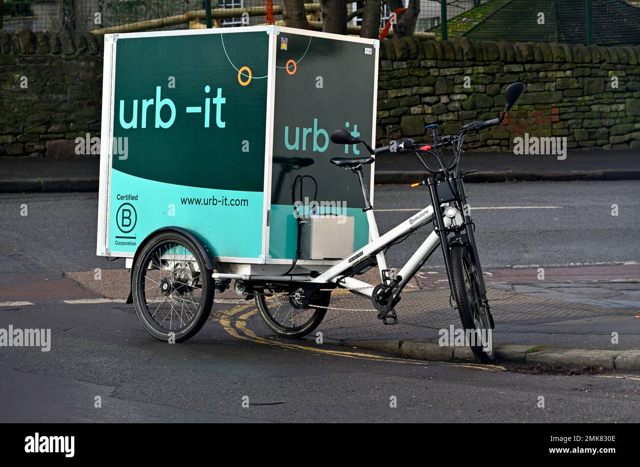 Cargo bike used for delivering parcels by cycle courier urb-it illegally parked on double yellow lines directly on corner and blocking pedestrian acce Stock Photo