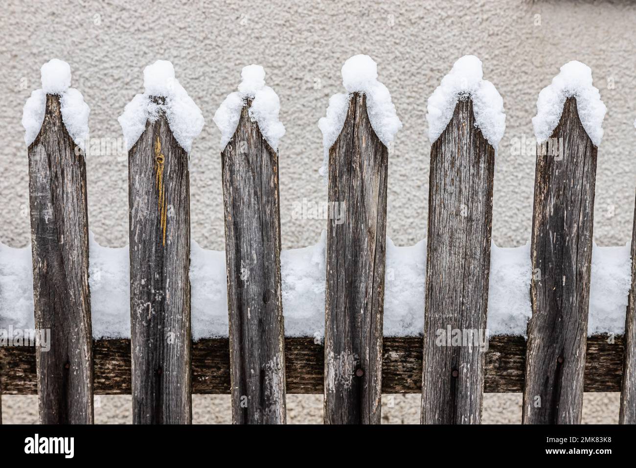 An old wooden picket fence in the village in winter. Snow on the fence. Selective focus. Stock Photo