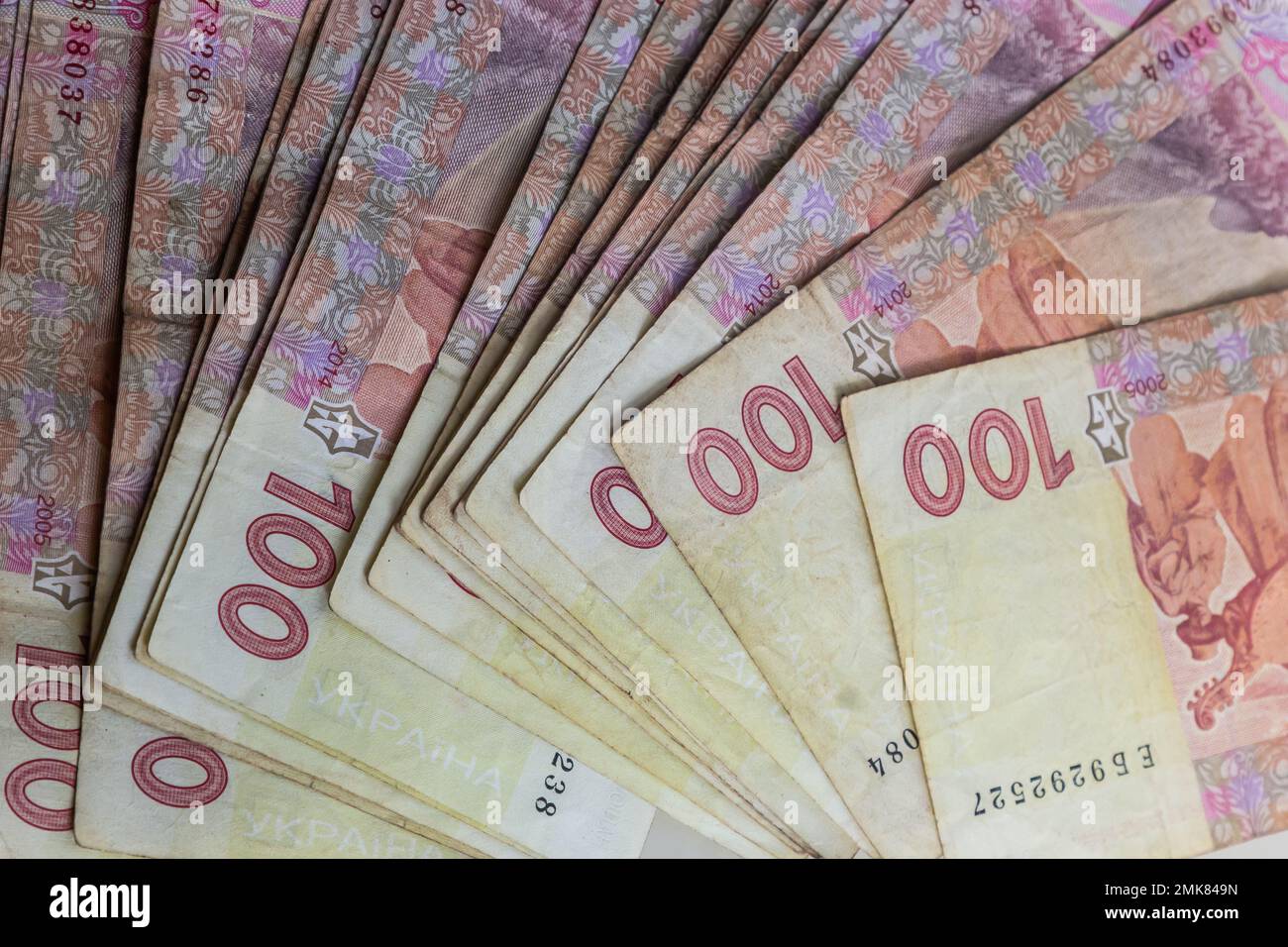Ukrainian paper money is laid out on a blue background. 100 hryvnia banknotes. Stock Photo