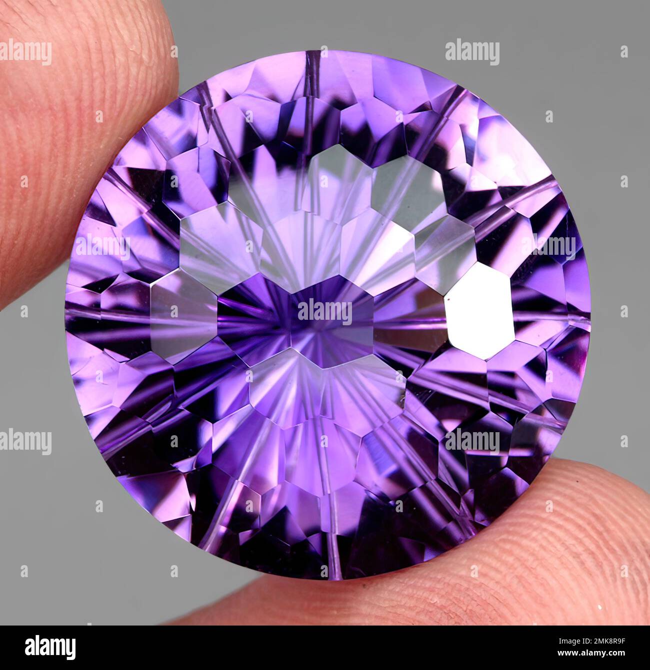 Natural gem purple amethyst on gray background Stock Photo