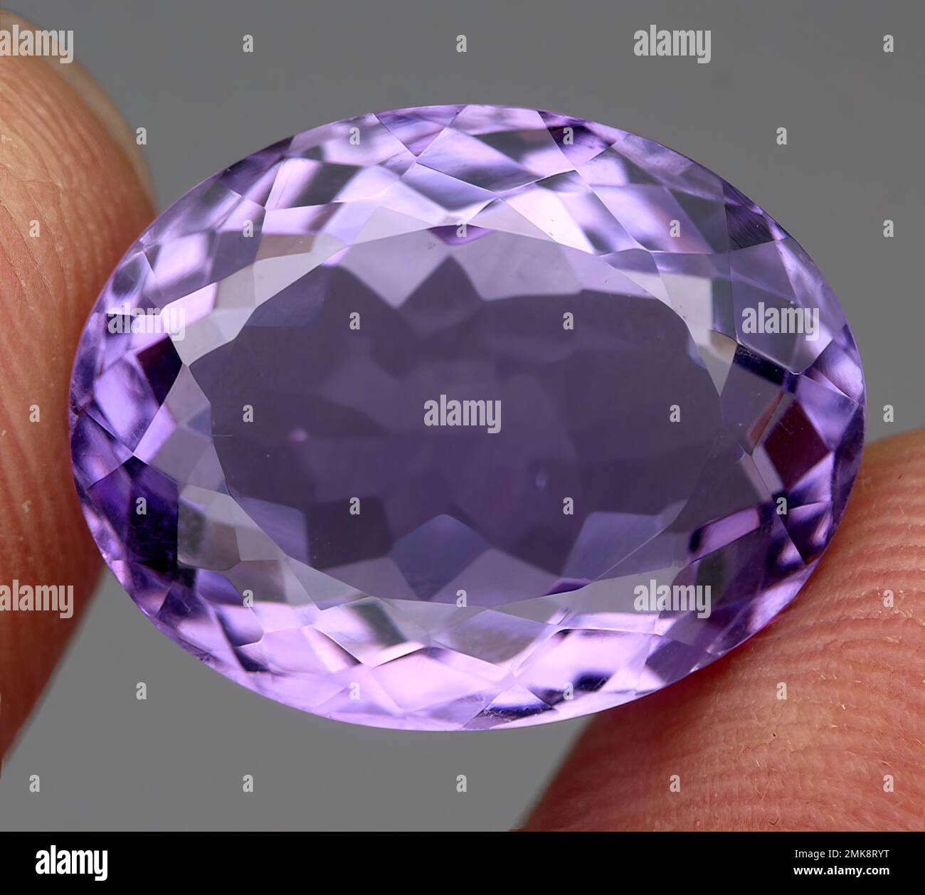 Natural gem purple amethyst on gray background Stock Photo