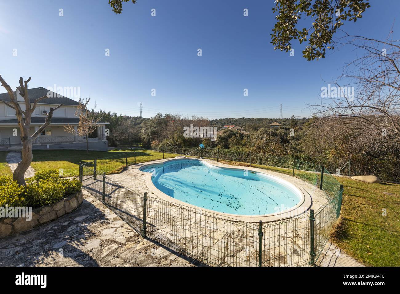 Solitary single-family house with a large plot with a kidney-shaped pool and views of the mountains Stock Photo
