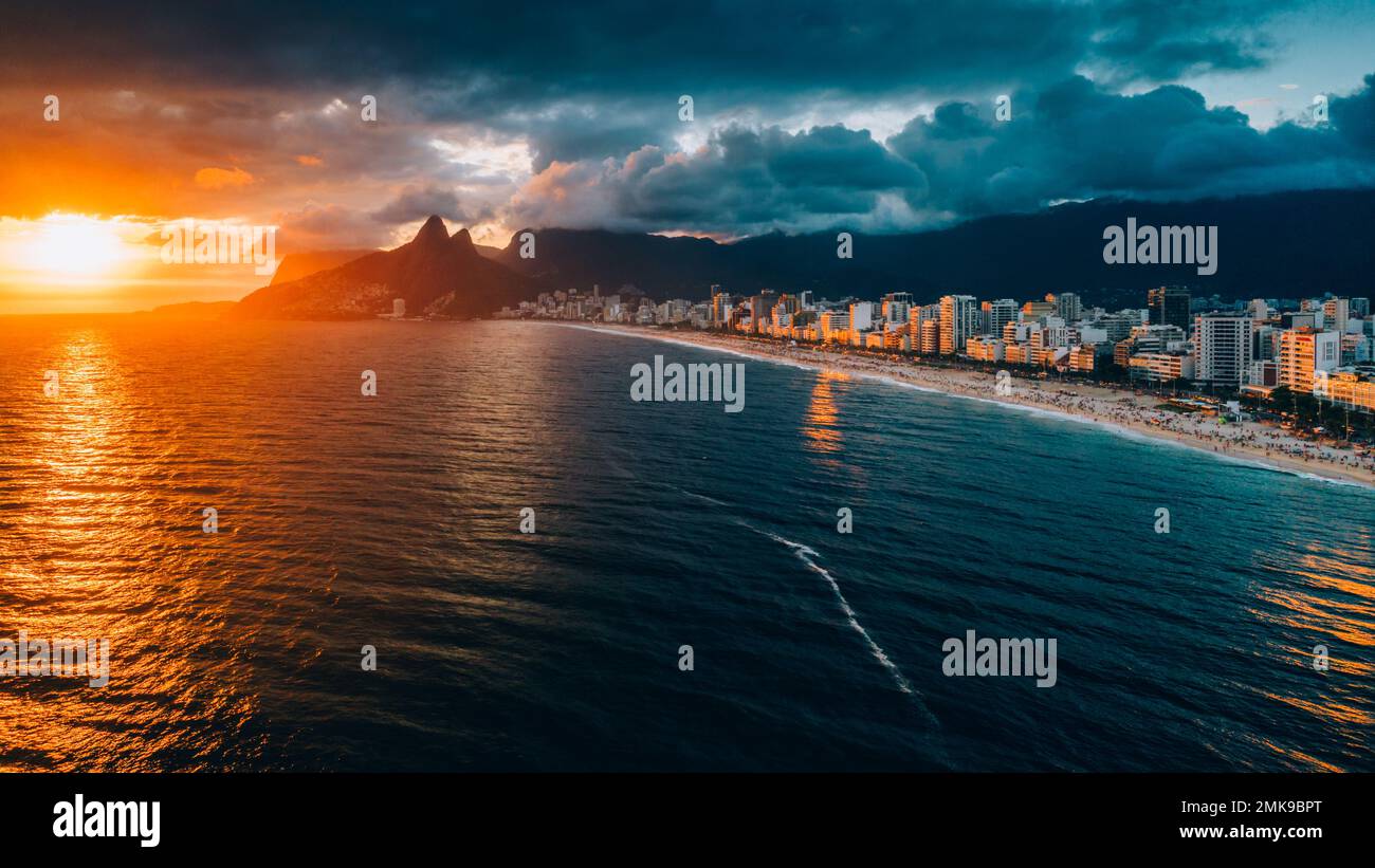 Aerial drone view of Ipanema Beach in Rio de Janeiro, Brazil at sunset with the iconic Two Brother mountains in the background Stock Photo