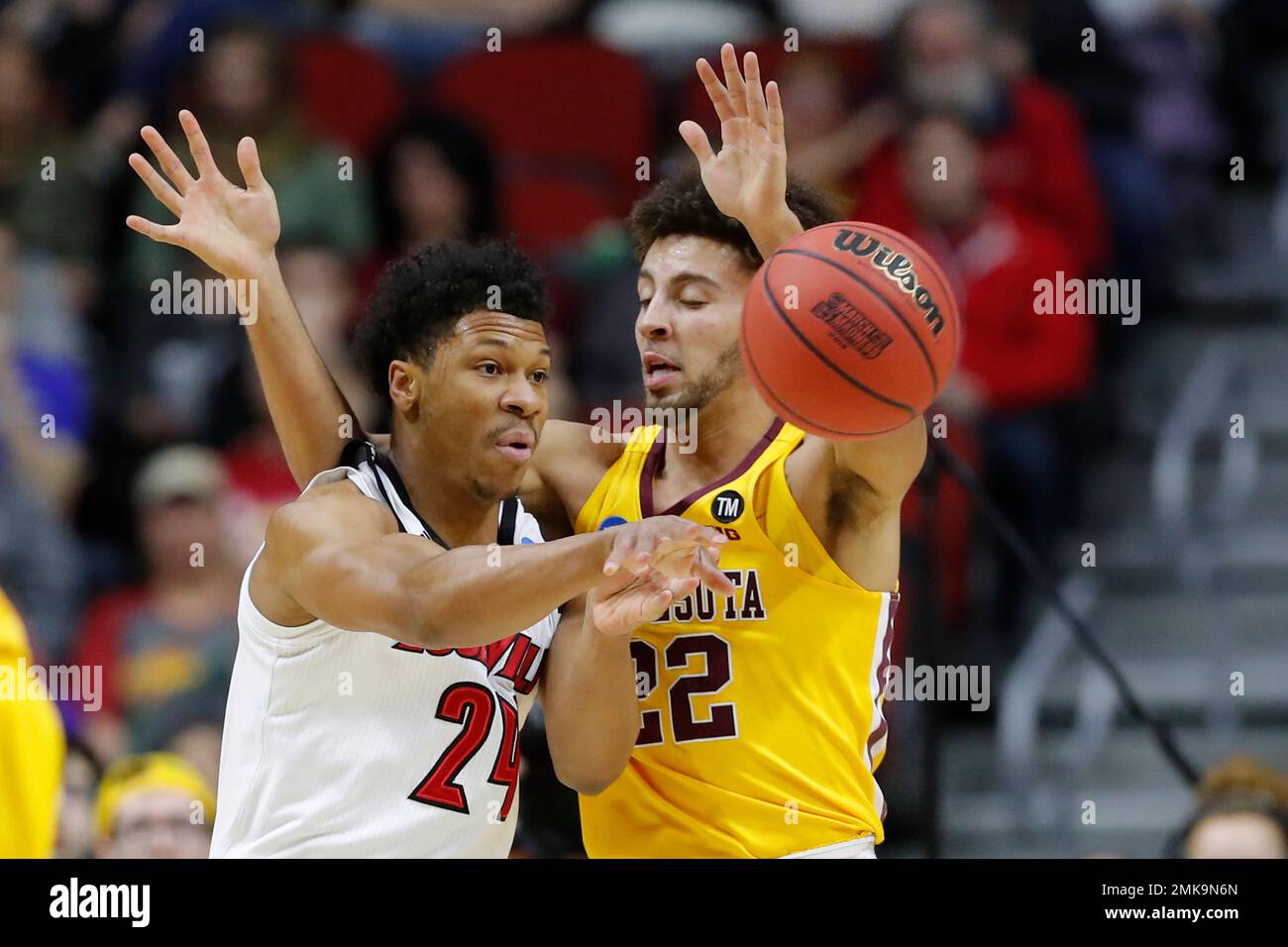 Louisville forward Dwayne Sutton passes around Minnesota guard Gabe  Kalscheur, right, during a first round men's college basketball game in the  NCAA Tournament, Thursday, March 21, 2019, in Des Moines, Iowa. (AP