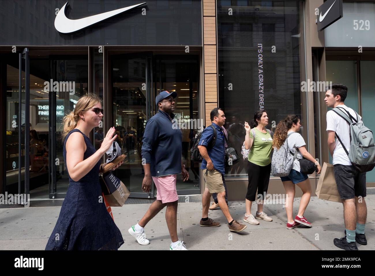 FILE- In this Sept. 4, 2018, file photo people pass a Nike store in New  York. Nike Inc. reports financial results Thursday, March 21, 2019. (AP  Photo/Mark Lennihan, File Stock Photo - Alamy