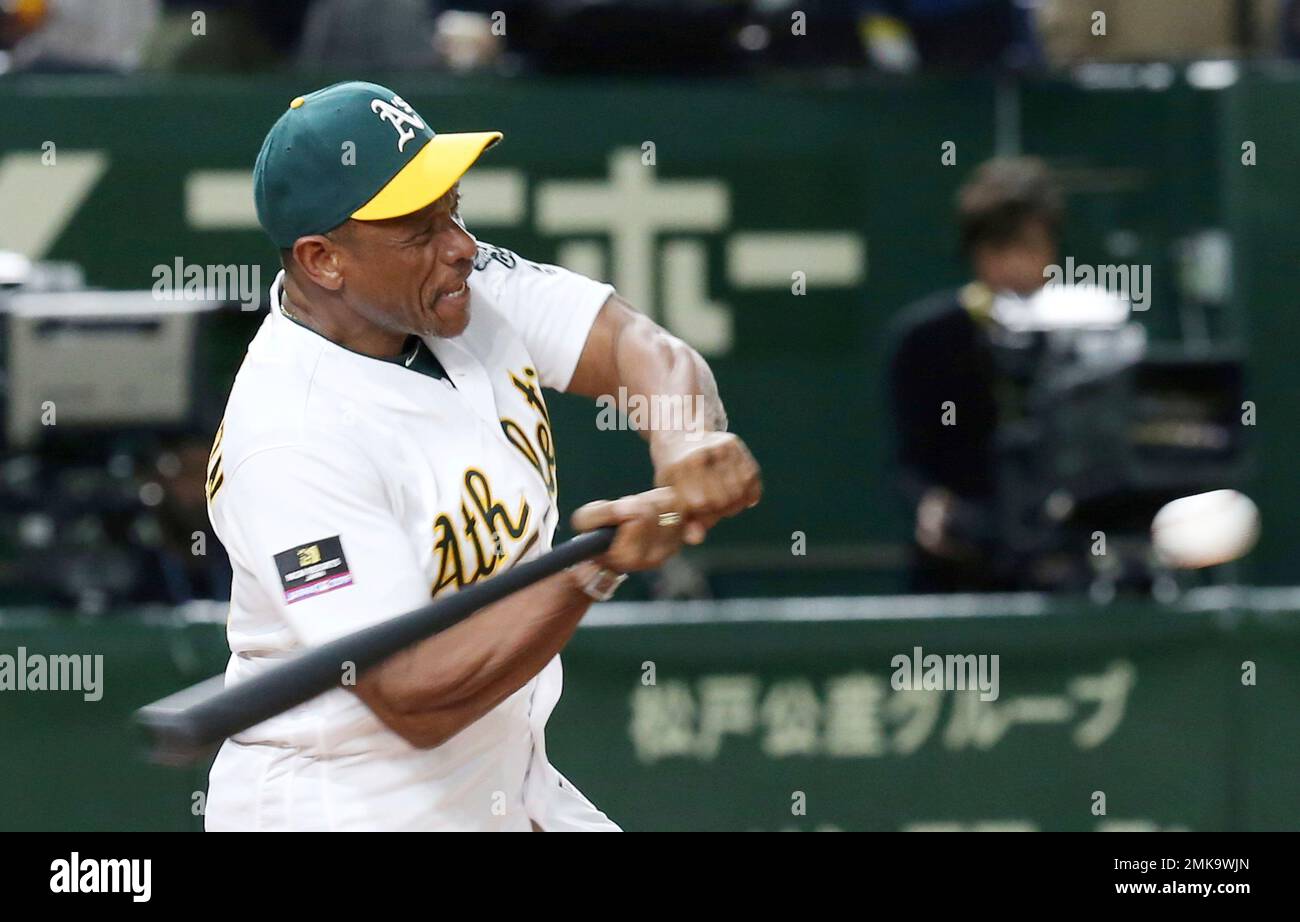 Former Oakland Athletics' Ricky Henderson swings during the ceremonial  first pitch prior to Game 1 of the Major League baseball opening series  between the Seattle Mariners and the Athletics at Tokyo Dome