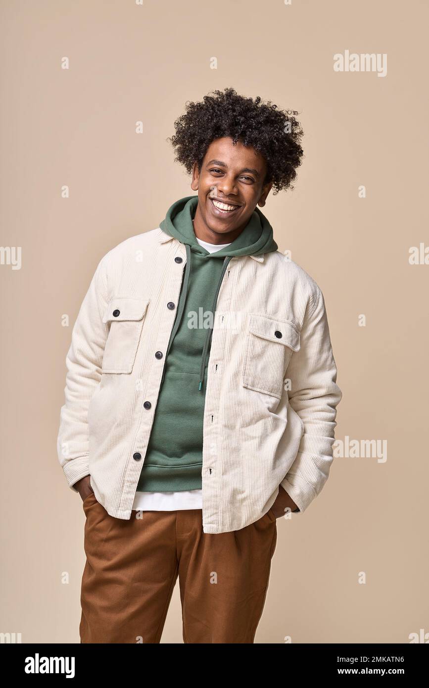 Smiling African American teen boy isolated on beige background. Vertical Stock Photo