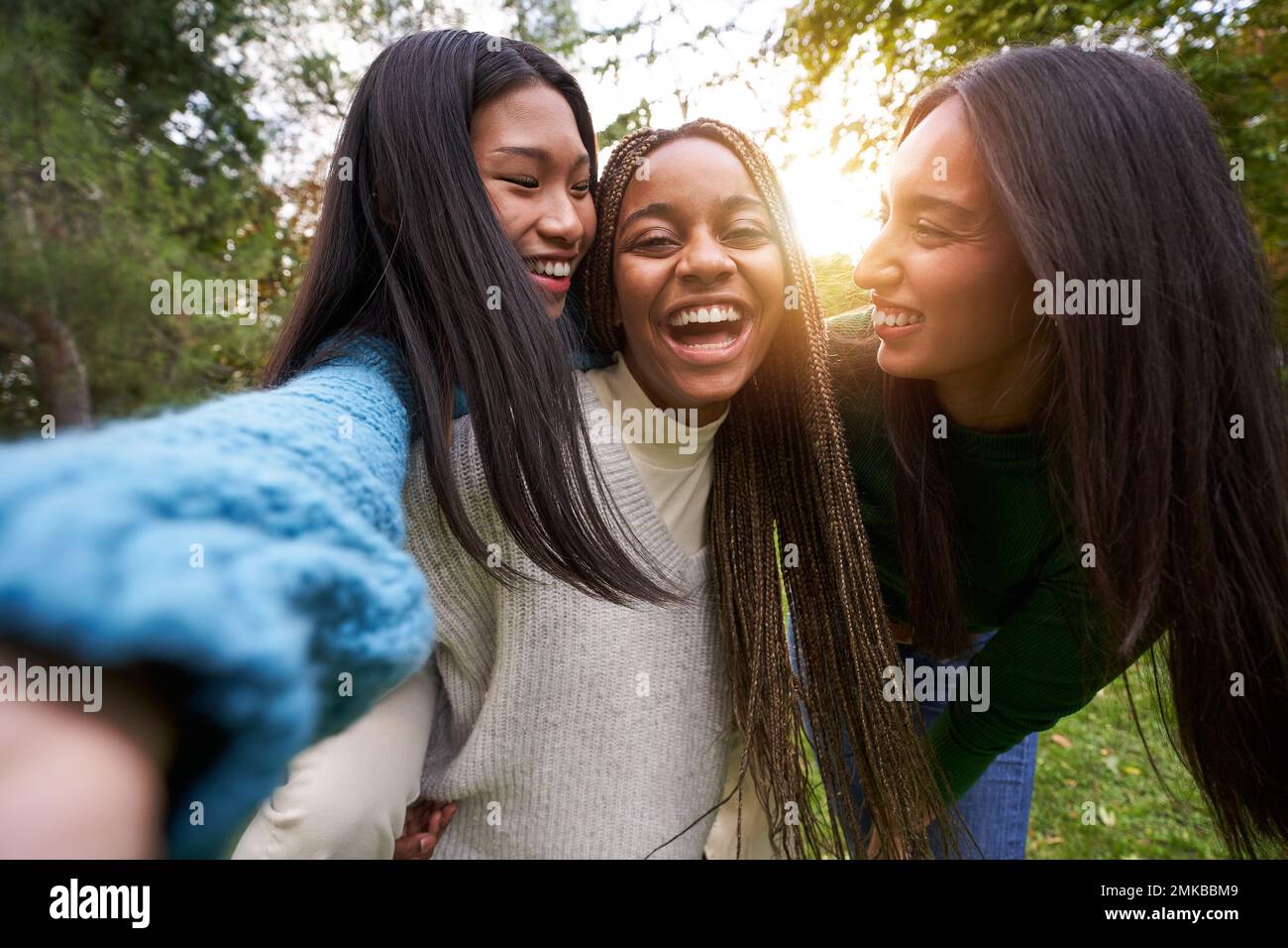 Portrait of three girls outside having fun taking selfie Friendship in multi-ethnic groups of people Stock Photo
