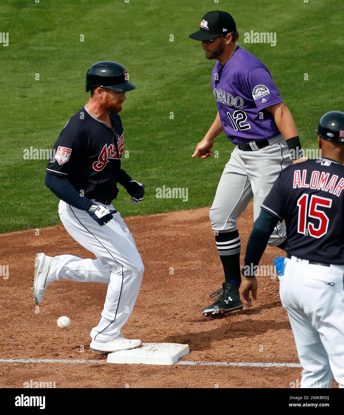 Cleveland Indians Jordan Ludlow, left, reaches first safely after a third  strike-past ball during the fourth inning of a spring training baseball  game against the Colorado Rockies, Saturday, March 9, 2019, in