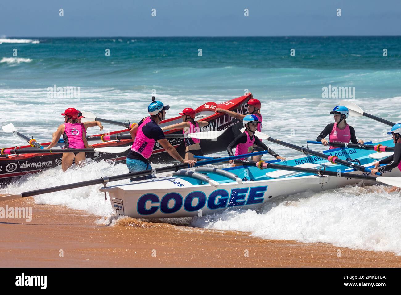 Womens surfboat racing carnival at North Narrabeen beach in Sydney, traditional surfboat from local surf life saving clubs compete,NSW,Australia Stock Photo