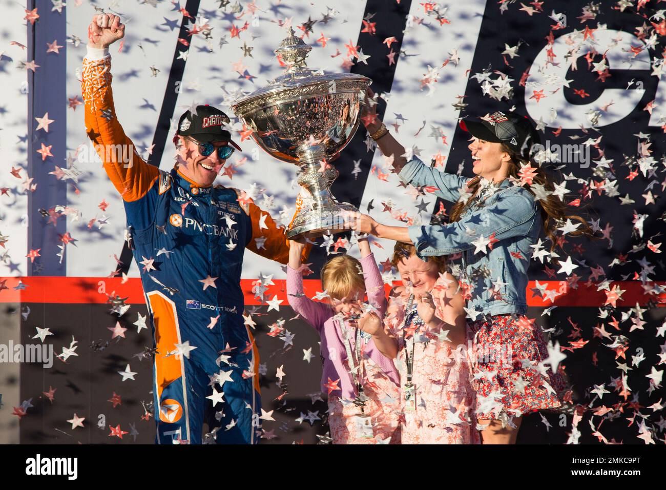 FILE - In this Sept. 16, 2018, file photo, Scott Dixon holds the Indy Car  Championship trophy with his wife Emma Davies and their children Poppy and  Tilly Davies Dixon, in Sonoma,, image size:1300x956