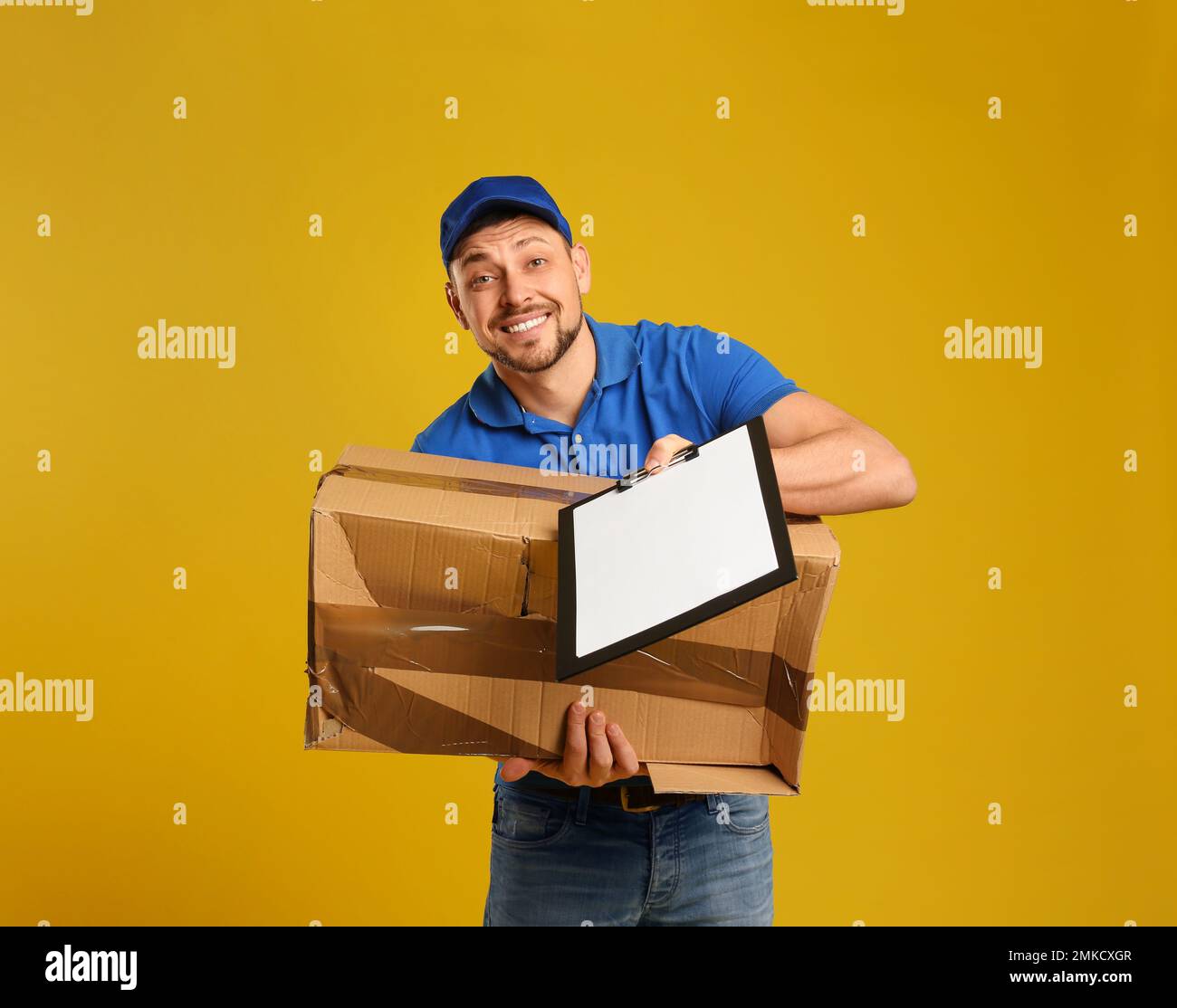 Emotional courier with damaged cardboard box and clipboard on yellow