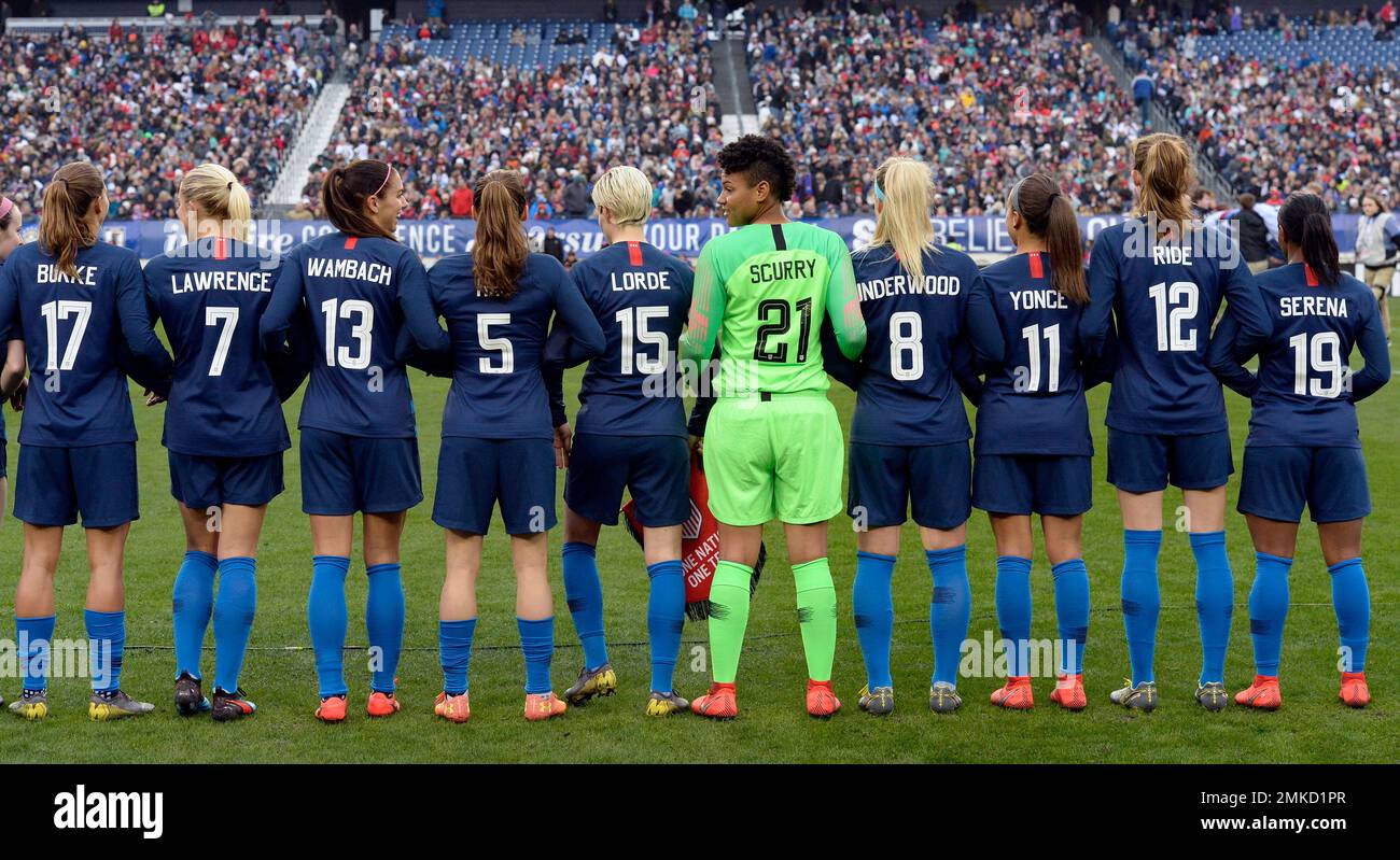 The United States women's national team stand arm-in-arm on the pitch ...