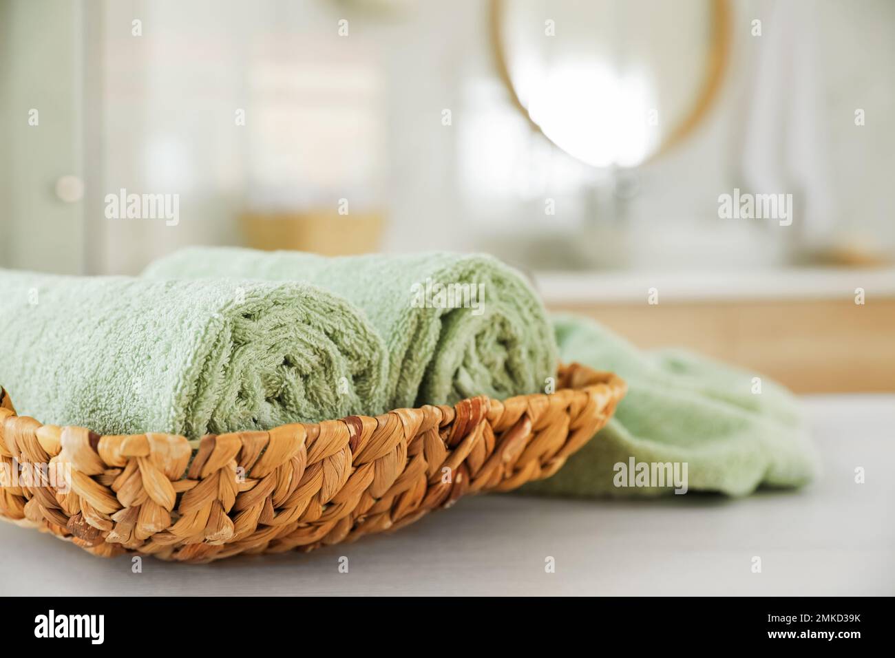 Wicker basket with rolled towels on white wooden table in bathroom Stock Photo Alamy