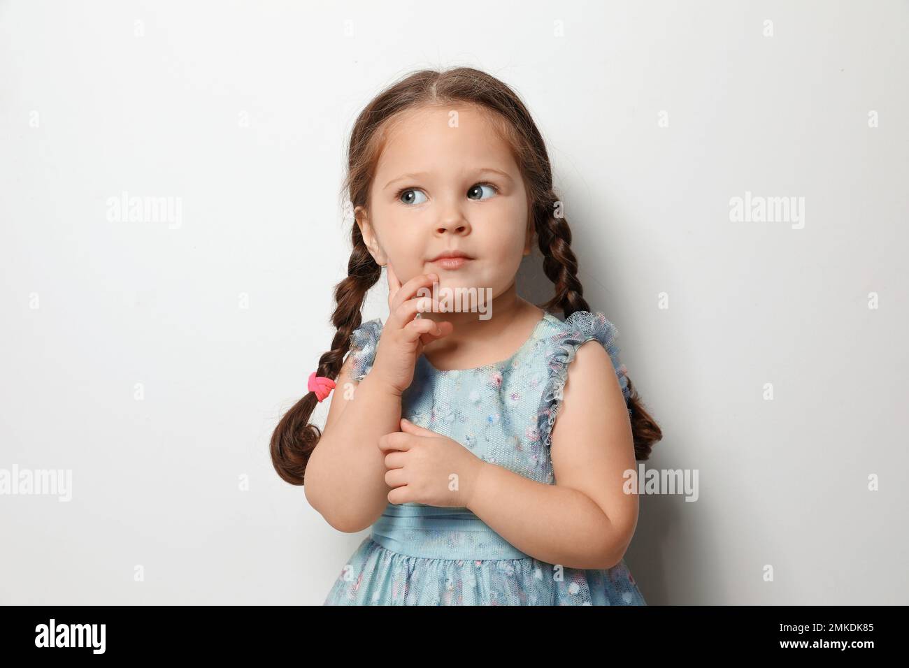 Cute little girl on light grey background Stock Photo Alamy