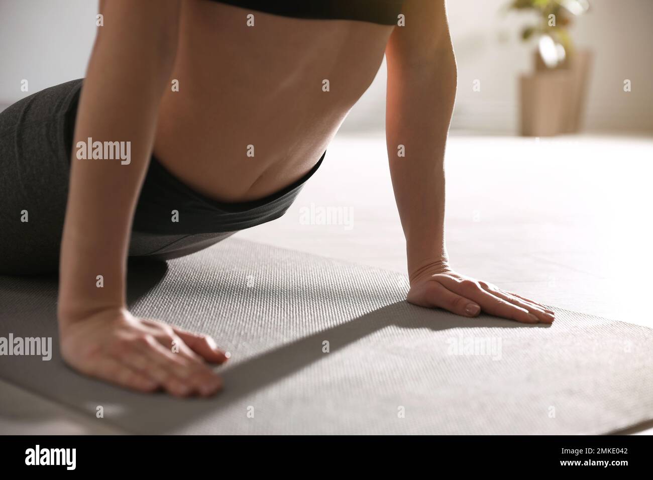 Young woman practicing cobra asana in yoga studio, closeup ...