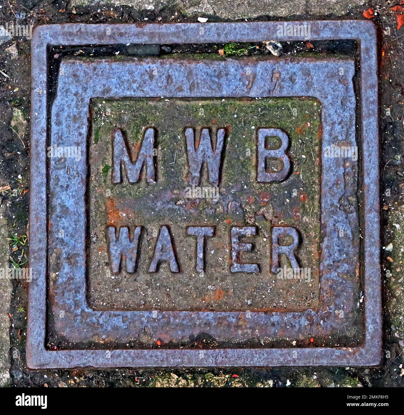 MWB water embossed cast iron grid, in a Wigan street, Lancashire, England Stock Photo