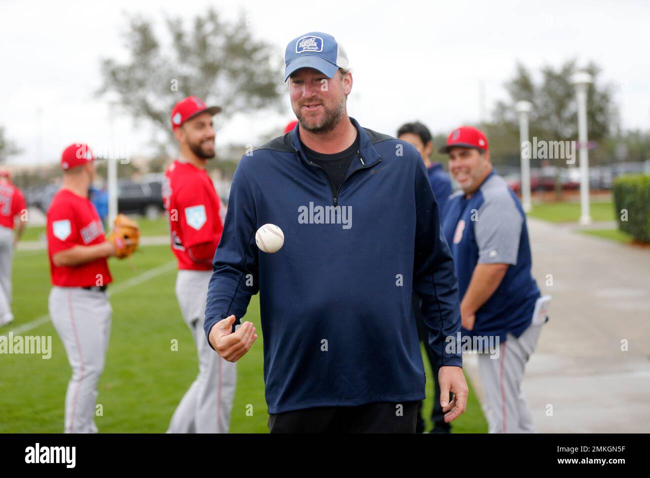 Former Boston Red Sox pitcher Derek Lowe tosses a ball as pitchers and catchers report for their