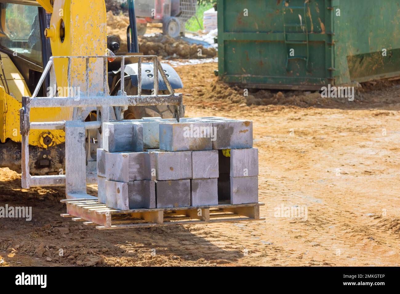 Forklift with boom truck moving cement blocks to place where wall of house will be installed Stock Photo
