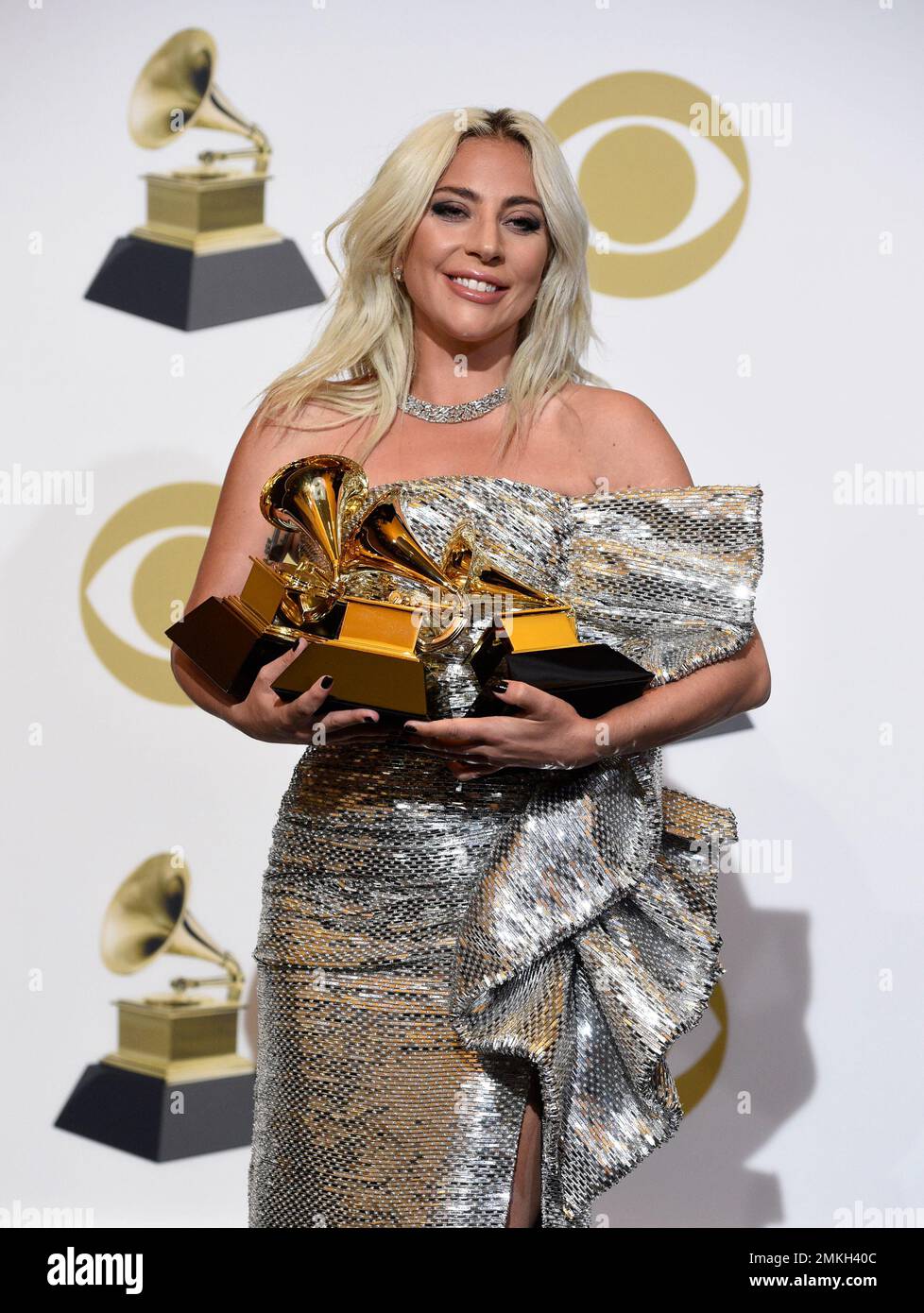 Lady Gaga poses in the press room with her awards for best pop solo
