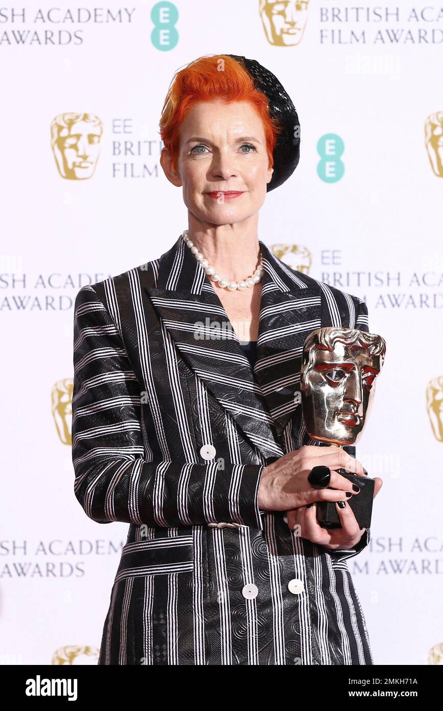 Designer Sandy Powell poses for photographers backstage with her Best