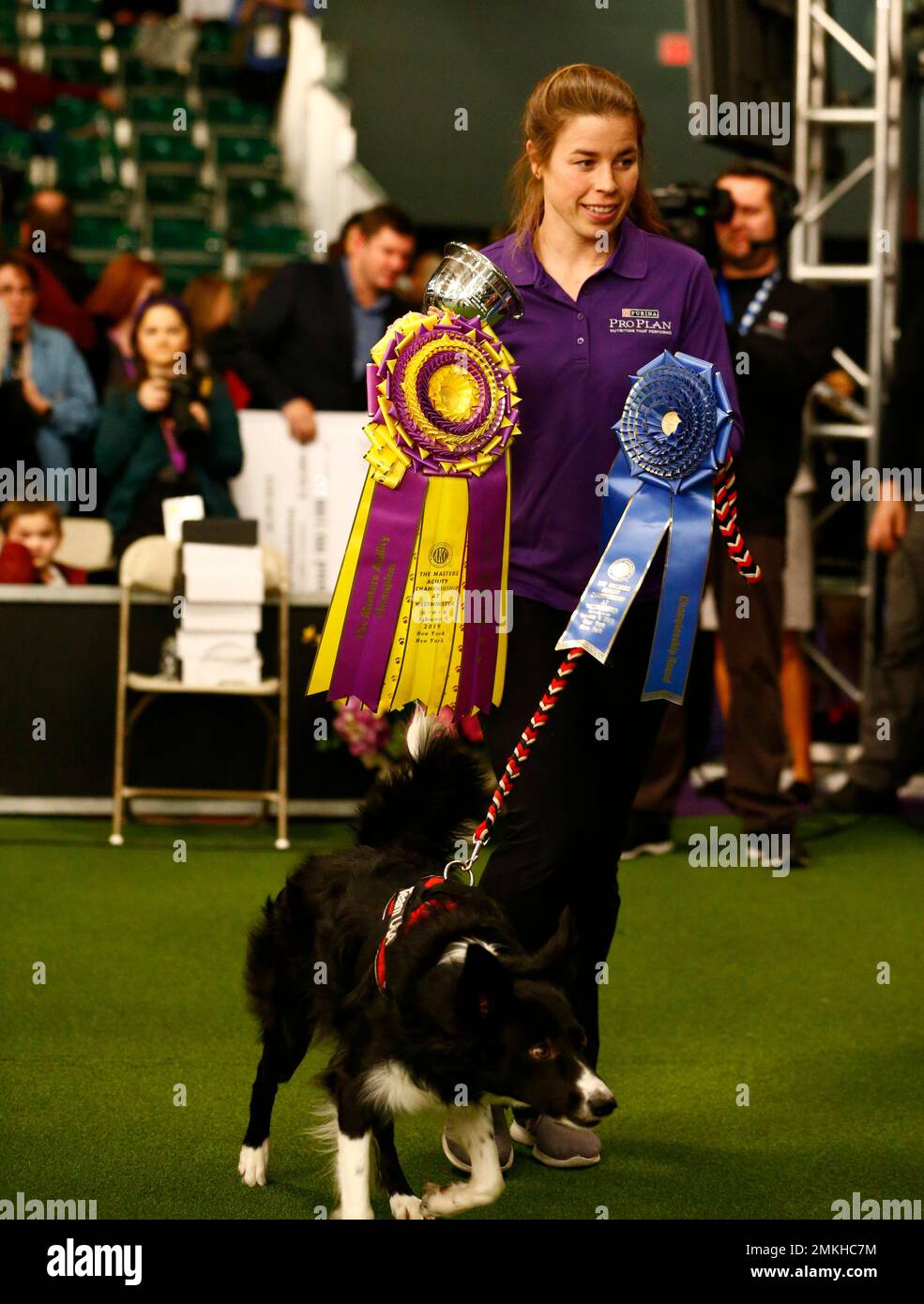 Perry DeWitt stands with her border collie "Verb" after winning the