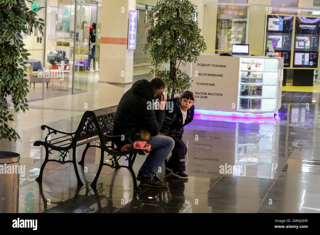 Saint Petersburg, Russia. 28th Jan, 2023. A man and a child are seen resting on a bench at the Shopping and entertainment complex ''Continent'' on Baikonurskaya Street in St. Petersburg. (Credit Image: © Maksim Konstantinov/SOPA Images via ZUMA Press Wire) EDITORIAL USAGE ONLY! Not for Commercial USAGE! Stock Photo