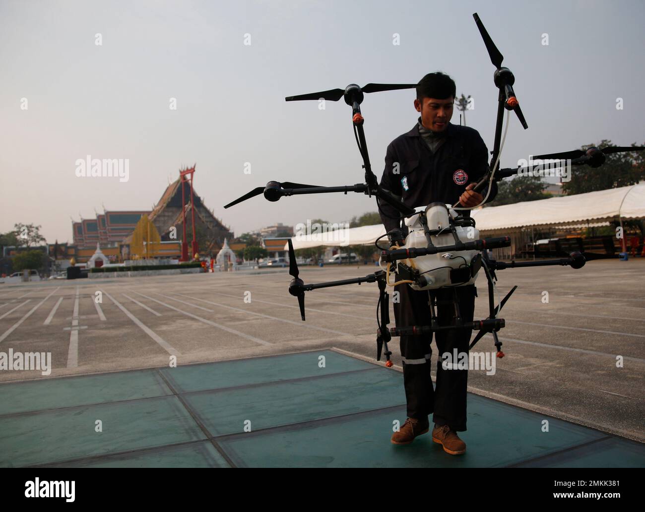 Drone pilots prepare to launch a waterspraying drone before flying