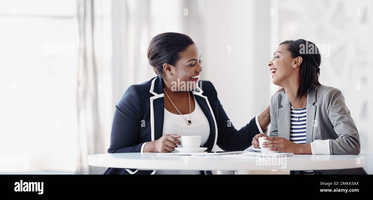 The happiest workplaces are the most successful ones. two attractive young businesswomen having a laugh while working together in their office. Stock Photo