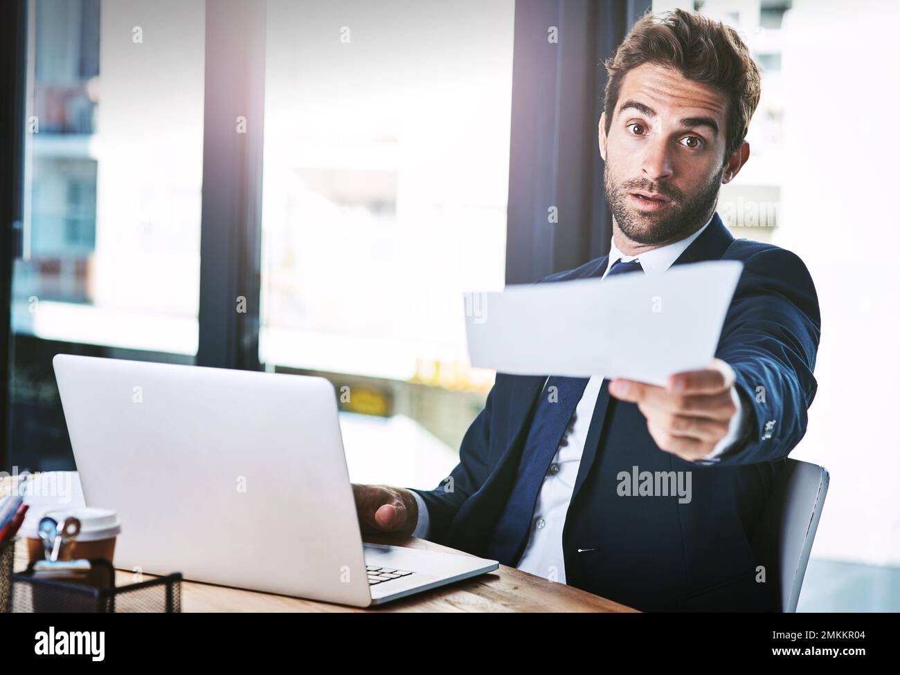 Get this done, now. Cropped portrait of a handsome young businessman looking serious while handing you a document. Stock Photo