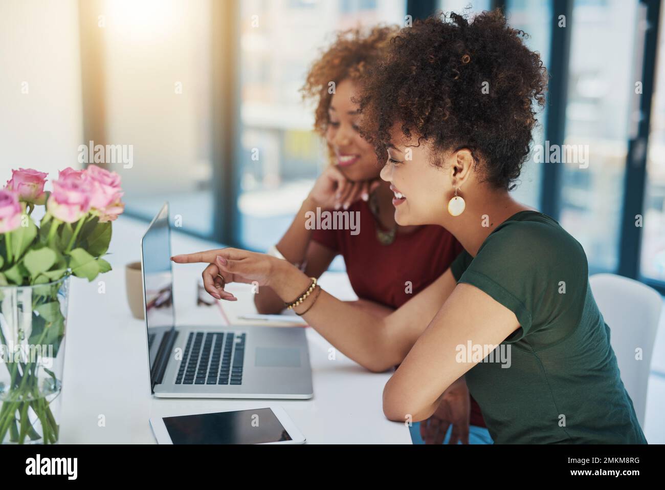 This one looks perfect. two young designers working on a laptop together. Stock Photo