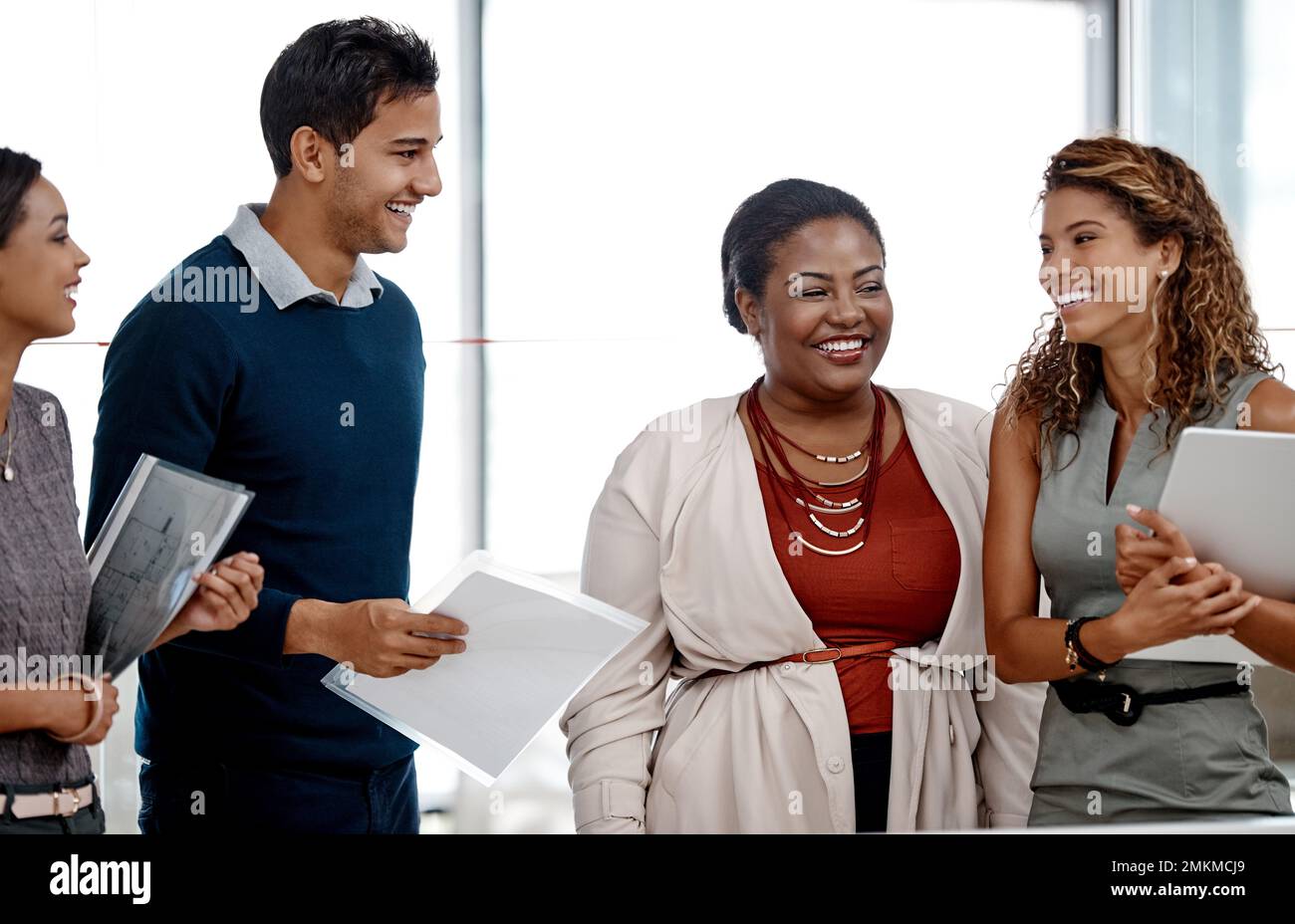 Were always making work fun. a young diverse group of colleagues sharing a laugh together in the office. Stock Photo