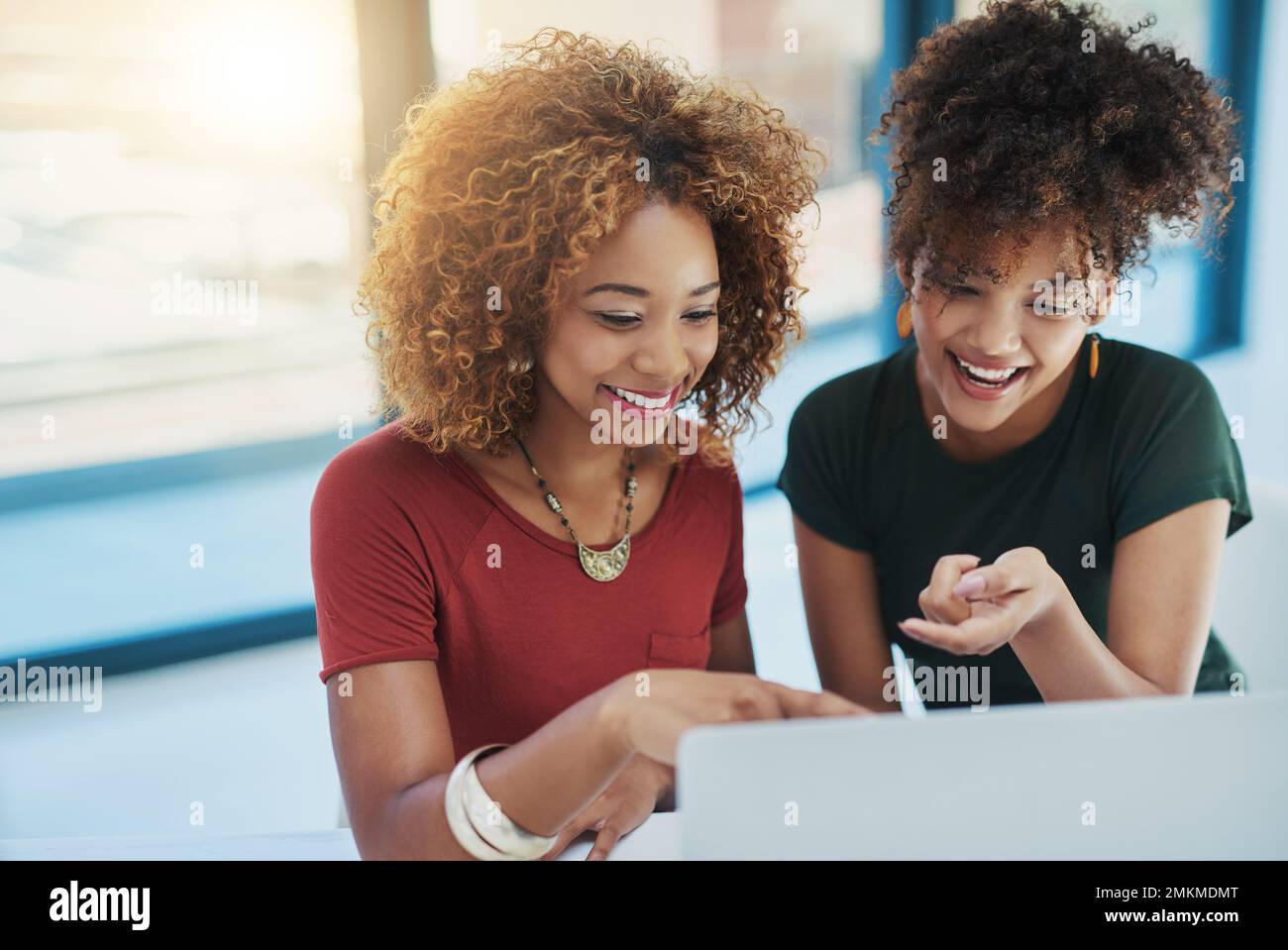 Happiness inspires productivity. two young designers working on a laptop together. Stock Photo