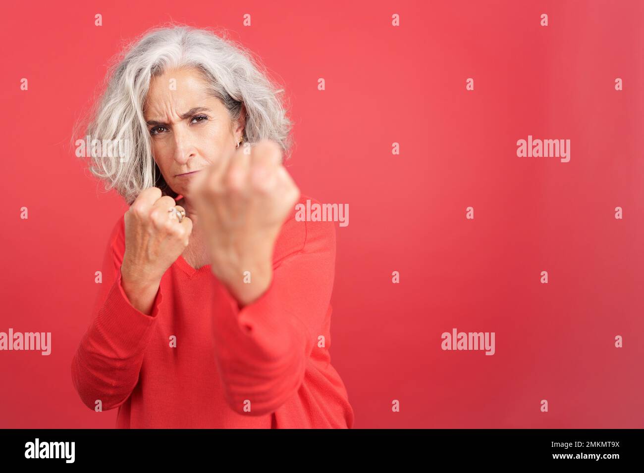 Mature woman confronting the camera with her fists Stock Photo